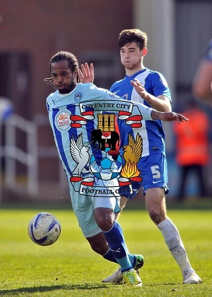 Intense Rivalry: A Clash Between Jack Baldwin and Nathan Delfouneso in the Sky Bet League One Match between Peterborough United and Coventry City