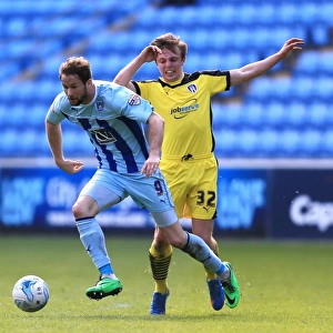 Coventry City sNick Proschwitz (left) and Colchester Uniteds Tom Lapslie battle for the ball