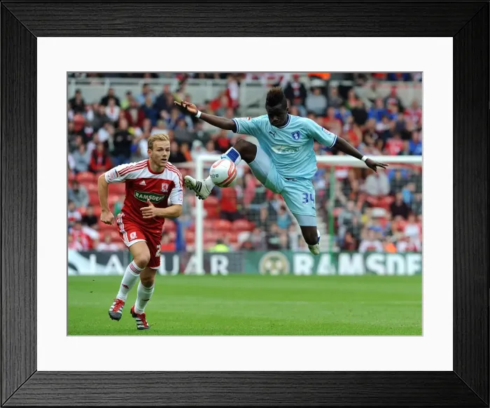 Framed Print : Gael Bigirimana Soars High: Coventry City vs Middlesbrough in Championship Action Framed Print : Gael Bigirimana Soars High: Coventry City vs Middlesbrough in Championship Action