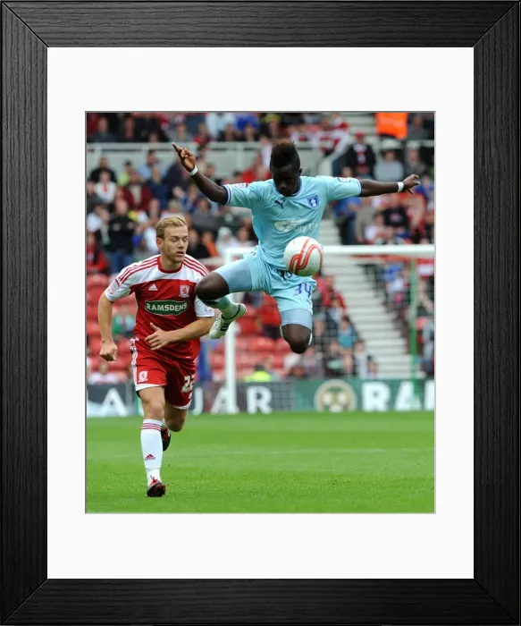 Framed Print : Soaring High: Gael Bigirimana's Aerial Mastery in Coventry City's Championship Battle at Middlesbrough (2011)