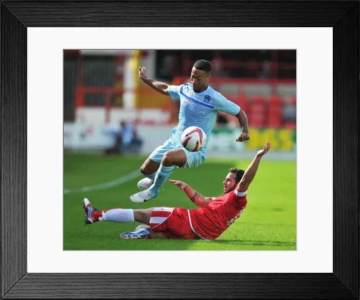 Framed Print : Jordan Clarke Soars Above Lee Moleneux in Coventry City's Pre-Season Clash at Crown Ground Framed Print : Jordan Clarke Soars Above Lee Moleneux in Coventry City's Pre-Season Clash at Crown Ground