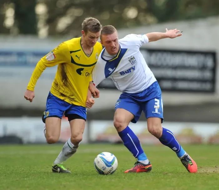 Framed Print : Battling for Control: Carl Baker vs. Joe Skarz in Npower League One Clash at Gigg Lane Framed Print : Battling for Control: Carl Baker vs. Joe Skarz in Npower League One Clash at Gigg Lane