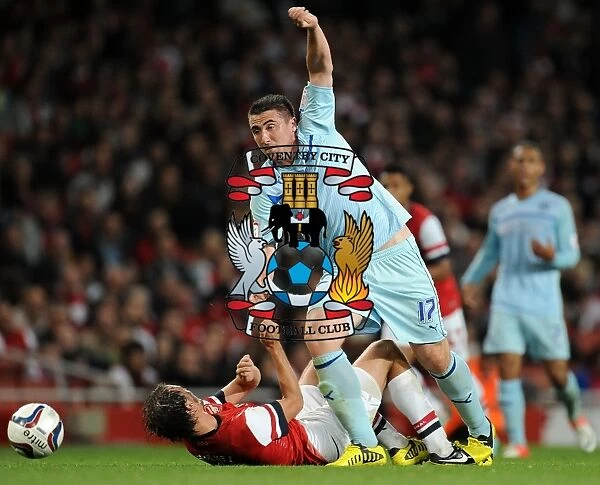 Callum Ball Dodges Ignasi Miquel in Coventry City's Capital One Cup Showdown at Arsenal's Emirates Stadium