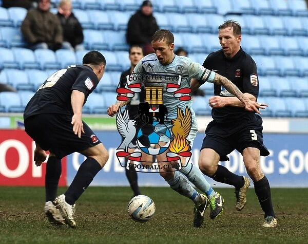 Clash at Ricoh Arena: Coventry City's Carl Baker Sandwiched Between Hartlepool's Defenders