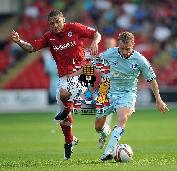 Gary McSheffrey vs. Nathan Doyle: Intense Battle for Ball Possession in Coventry City's Npower Championship Clash at Barnsley's Oakwell Stadium