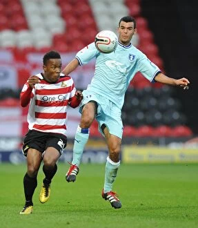 29-10-2011 v Doncaster Rovers, Keepmoat Stadium Collection: Battle for the Ball: Thomas vs. Dumbuya in Coventry City's Championship Clash