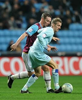 Images Dated 19th November 2011: Carl Baker Avoids Glance: Tense Moment between Coventry City's Baker and West Ham's Nolan
