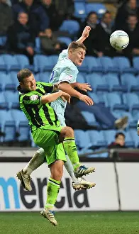 Images Dated 2011 December: Clash at Ricoh Arena: Footballers Leap for the Ball - Coventry City vs