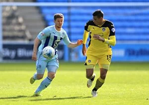 Images Dated 11th April 2015: Coventry Citys Aarom Phillips (left) and Colchester Uniteds Matthew Briggs battle for the ball