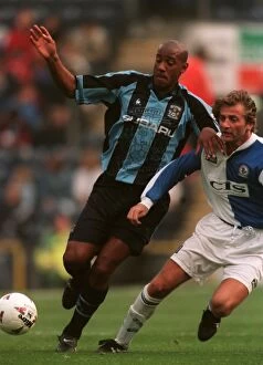 Images Dated 28th September 1997: Dion Dublin's Determined Standoff Against Blackburn Rovers in FA Carling Premiership Clash