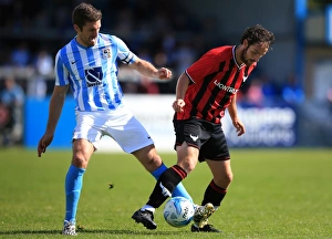 Prints of Coventry Citys Sam Ricketts battles for the ball with Oxford Uniteds Danny Hylton Pre-season Friendly Prints: Sam Ricketts vs Danny Hylton: A Battle for the Ball - Coventry City vs Oxford United (Pre-Season Friendly)